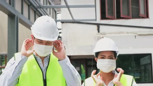 Construction Workers Putting on Protective Face Masks