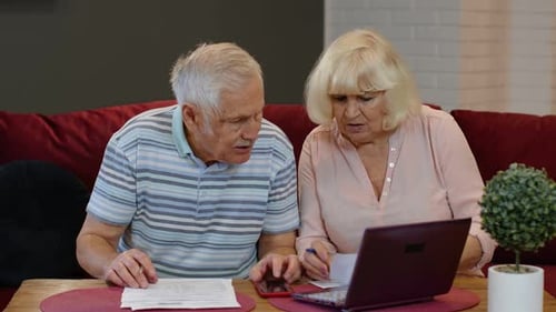 Senior Couple Checking Calculating Bills Bank Loan Payment Doing Paperwork Discuss Unpaid Debt Taxes