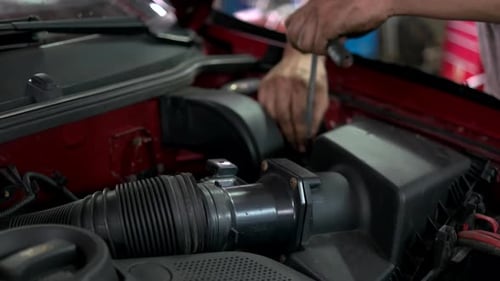 Repairman Unscrewing and Withdrawing Big Car Engine Detail