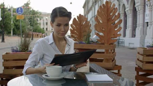 Women in Cafe Reading Menu