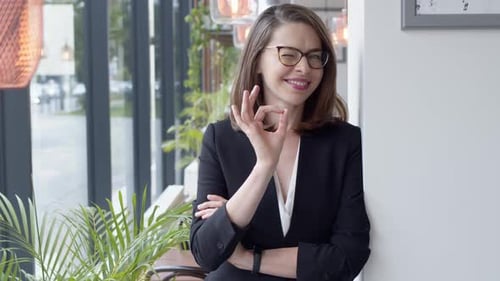 Portrait of Young Smiling Businesswoman Standing in Modern Office Interior