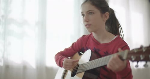 Girl Playing Guitar and Singing Indoors