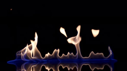 Raya de destello y fuego de líquido inflamable o gasolina sobre un fondo negro reflectante