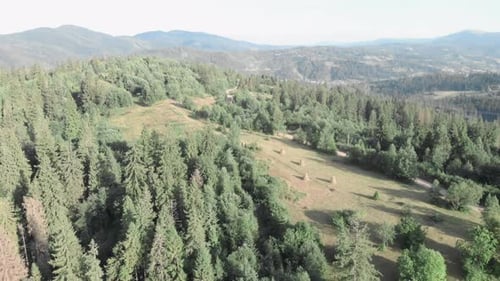 Aerial View of Mountains, Forest, and Hay Bales
