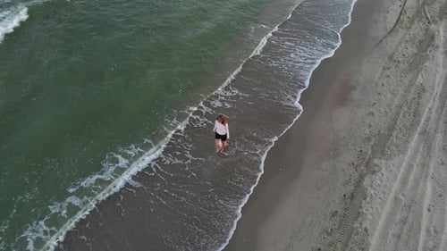 Beautiful Barefoot Woman Walking Along Deserted Beach