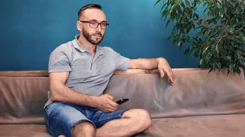 Man on Couch Using Mobile Phone Indoors