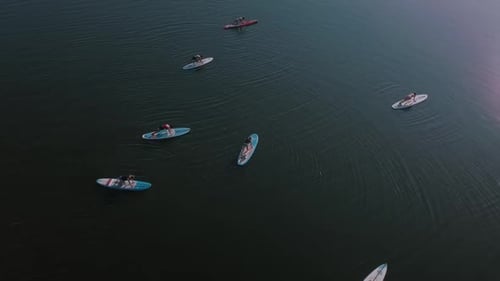 Flying and Shooting From a Drone’s Camera in a Circle Over a Group of People Doing Exercises for