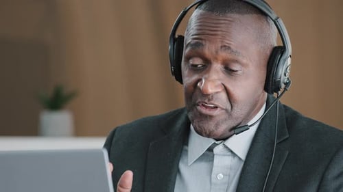 Professional Man Video Conferencing with Headset at Work
