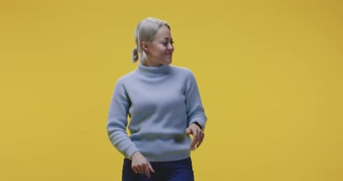 Happy Woman Dancing in Front of Yellow Background