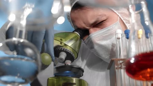 Scientist Viewing Sample Under High Powered Microscope