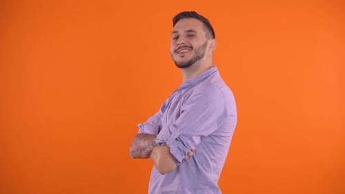 Sexy Handsome Man Winks and Sending a Kiss. Studio Shot, Orange Background Copy Space