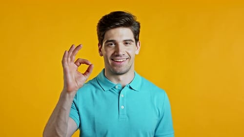 Man Giving Okay Gesture on Yellow Background
