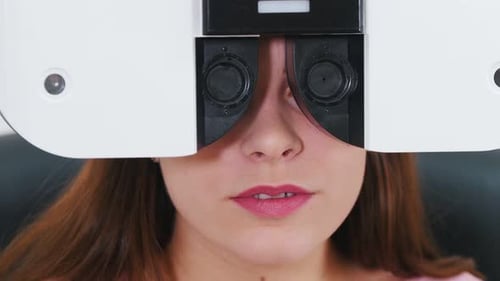 Junge Frau überprüft ihre Sehschärfe mit einer speziellen Optometrie