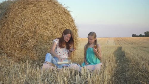 Mother And Daughter On A Picnic In A Wheat Field