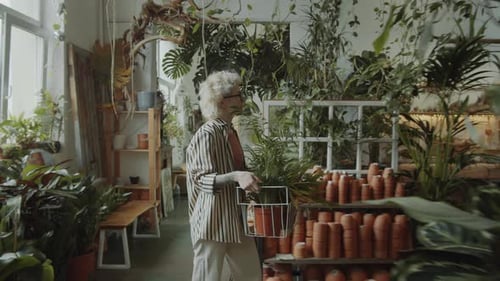 Female Florist Walking with Plants in Flower Store