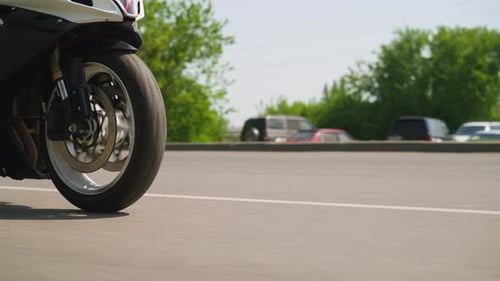 Motorcycle Drives Fast Along Empty Plain Road on City Street