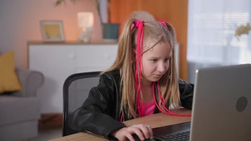 Child on Distance Learning Plays Video Games on a Laptop Portrait of Dependent Girl with Pink