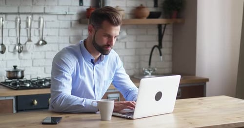 Focused Business Man Entrepreneur Typing on Laptop Doing Research