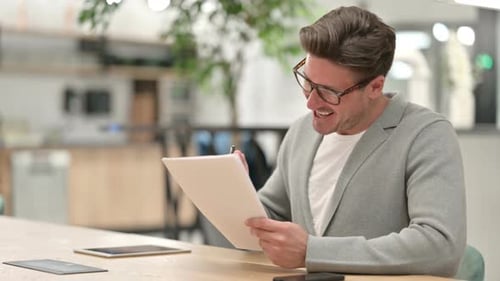 Middle Aged Man Having Success on Documents in Office