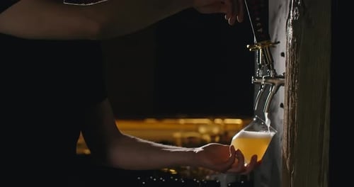 Bartender Pouring Craft Beer Into Glass at Bar