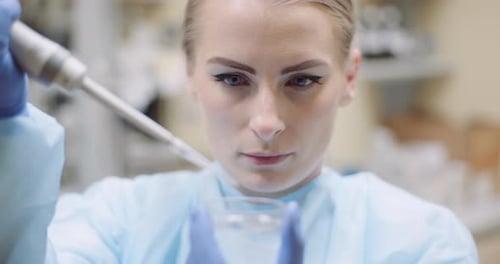 Woman Scientist Drops Liquid into Petri Dish
