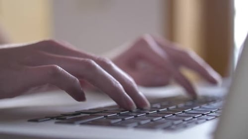 Hands Typing on Laptop Keyboard Close Up
