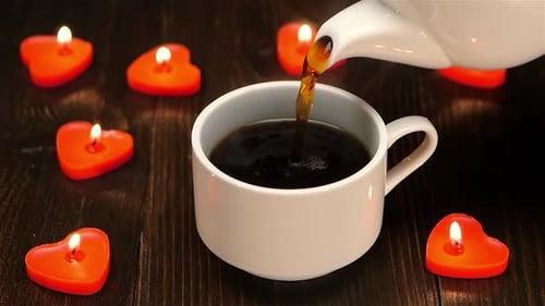 Coffee Poured Near Romantic Heart Candles