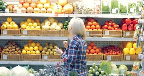 Woman Picking Vegetables in a Supermarket