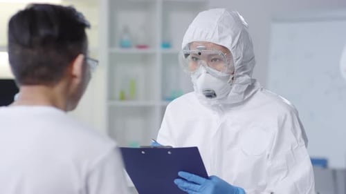 Scientist in Hazmat Suit Taking Notes in Lab