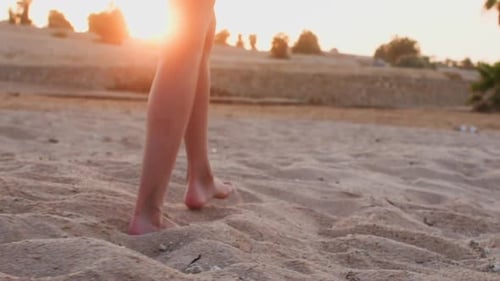 Barefooted Woman is Walking on the Sea Sand Beach at Sunset Legs Closeup