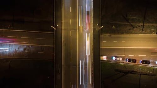 Aerial View of Road Intersection with Fast Moving Heavy Traffic at Night