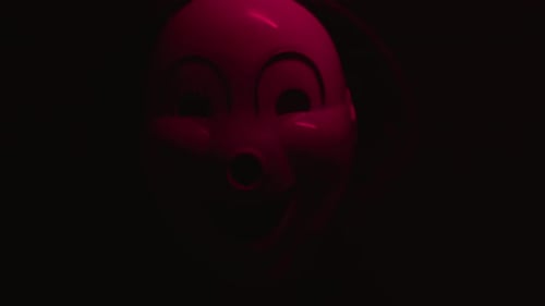 Pink Mask With Smiling Face on Dark Background