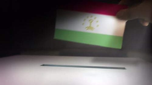 Hand Drops Tajikistan Flag Ballot into Election Box