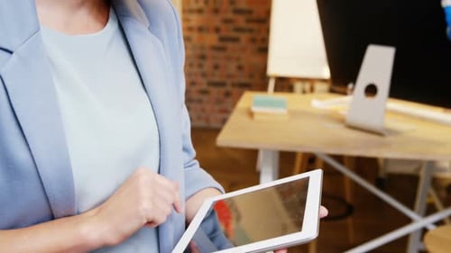 Smiling Woman Using Tablet in Modern Workplace