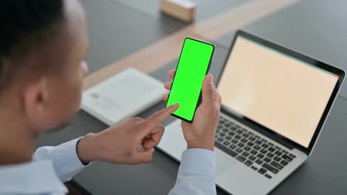 African Man Using Smartphone with Green Chroma Key Screen
