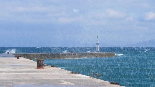 Waves hitting concrete wave breaker jetty, slow motion splash, Greece