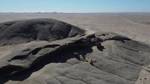 Vue aérienne imprenable sur un immense désert avec des montagnes à l'horizon, journée ensoleillée
