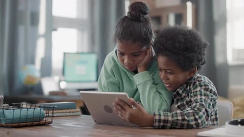 Children Looking at Tablet Together at Home