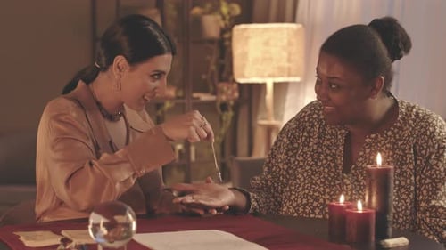 Diseuse de bonne aventure utilisant le pendule sur la main du client