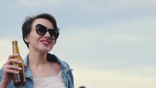 Beautiful Woman Drinking Beer And Dancing At Party Outdoors