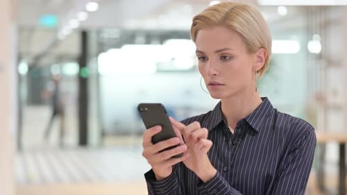 Woman Using Smartphone in Modern Office Environment