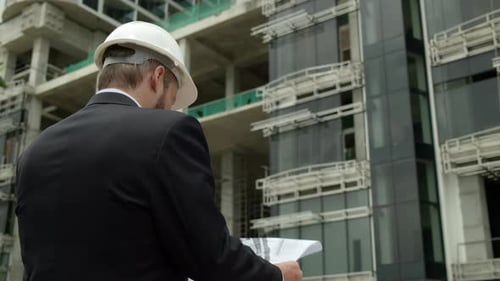Engineer Male Men Wearing Face Protective Mask Holding a Blueprint of the Building and Working