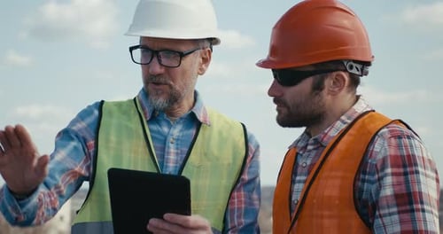 Ingeniero y técnico hablando en la azotea