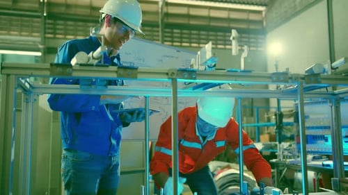 intelligenter asiatischer technischer Ingenieur, der mit der Montage arbeitet und am Konstruktionsprozess der Maschine beteiligt ist