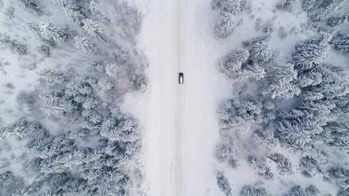 Autofahren auf einer verschneiten Straße im Wald