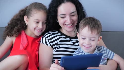 Smiling Family Using Tablet Device Together at Home