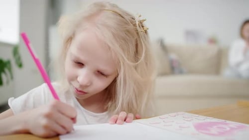 Blonde Child Drawing Mother's Day Card at Home