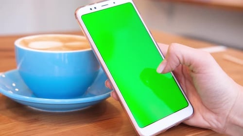 Woman Using Smartphone Viewing Green Screen on Mobile Phone Browsing Chroma Key Online Watching
