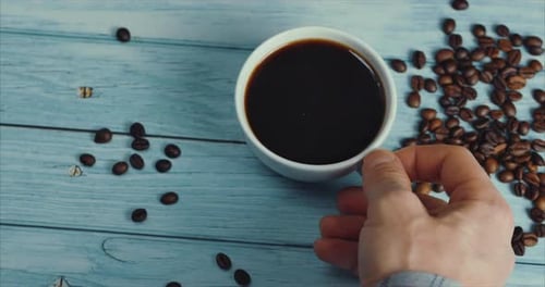 Hand Picking Up Cup of Black Coffee