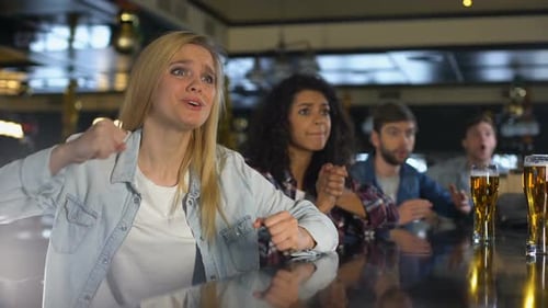 Beautiful Girl With Friends Watching Live Sports in Pub, Celebrating Victory